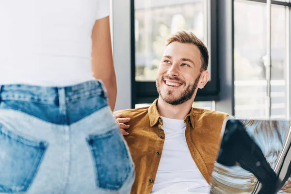 Schnappschuss eines lächelnden jungen Mannes und einer Frau, die während der gemeinsamen Arbeit im Büro flirten — Stockfoto