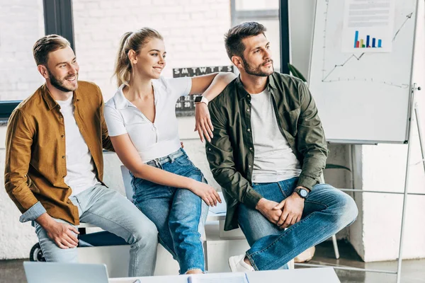 Grupo de jovens empresários sorridentes olhando juntos para o escritório — Fotografia de Stock