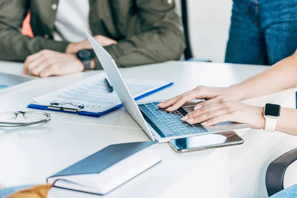 Cropped shot of business colleagues working together with documents and laptop at office — Stock Photo