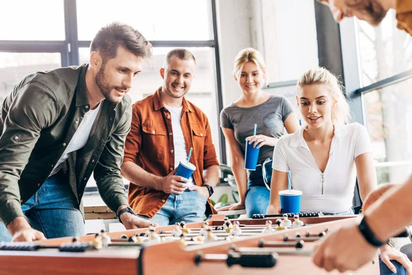 Cropped shot of expressive casual business people playing table football at office and having fun together — Stock Photo