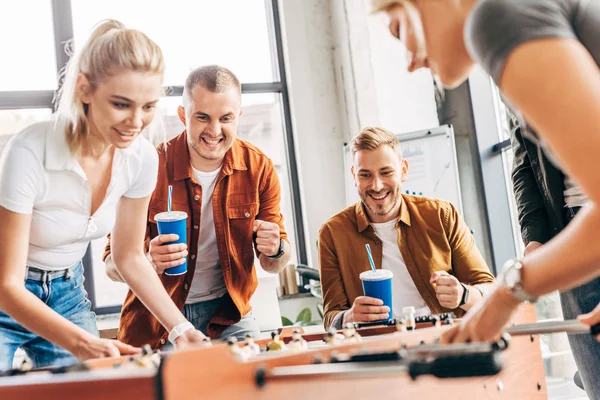 Espresso giovani uomini d'affari casual giocare a calcio balilla in ufficio e divertirsi insieme — Foto stock