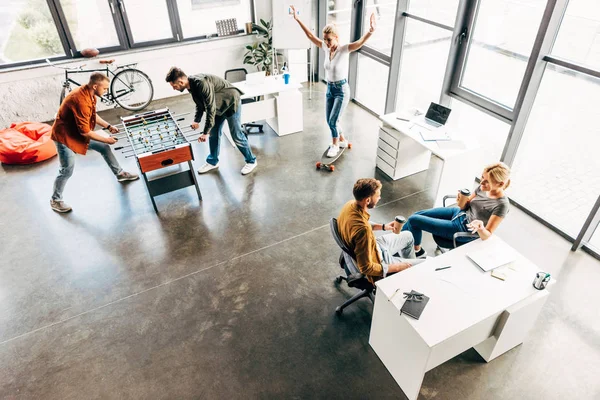Blick aus der Vogelperspektive auf eine Gruppe junger Unternehmer, die am Start-up arbeiten und gemeinsam Spaß im Büro haben — Stockfoto