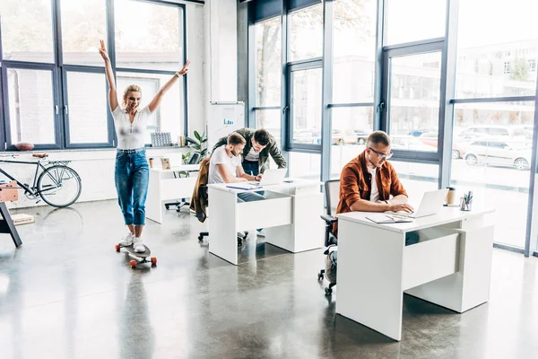 Grupo de jóvenes emprendedores felices que trabajan juntos en startup en la oficina moderna de espacio abierto - foto de stock