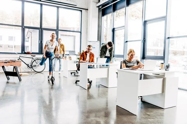 Grupo de jóvenes emprendedores progresistas que trabajan juntos en startup en la oficina moderna de espacio abierto - foto de stock