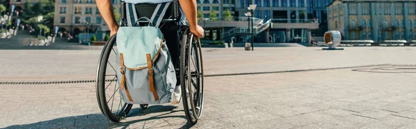 Обрезанный панорамный вид на человека с помощью инвалидного кресла с сумкой на улице — стоковое фото