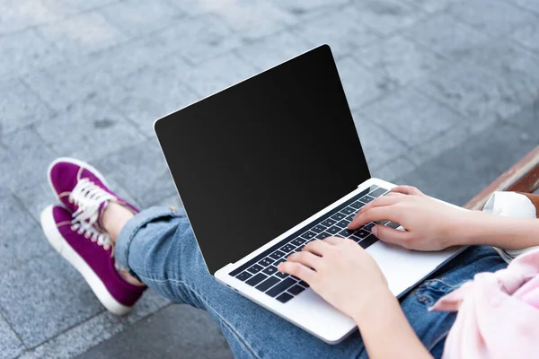 Обрезанное изображение фрилансера с помощью ноутбука с пустым экраном на улице — стоковое фото