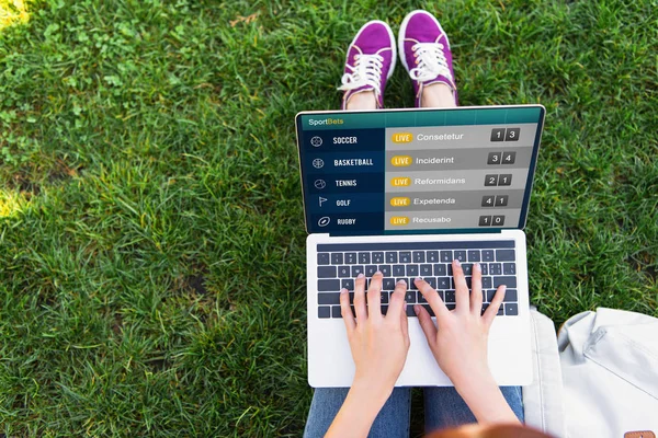 Cropped image of woman using laptop with sportbets appliance in park — Stock Photo