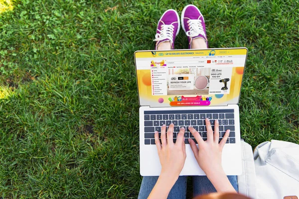 Abgeschnittenes Bild einer Frau mit Laptop und geladener aliexpress-Seite im Park — Stockfoto
