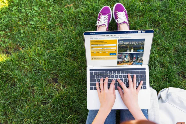 Abgeschnittenes Bild einer Frau mit Laptop und geladener Buchungsseite im Park — Stockfoto