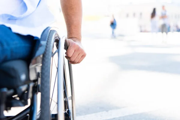 Imagen recortada de hombre discapacitado usando silla de ruedas en la calle - foto de stock