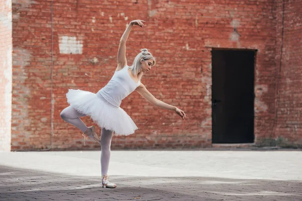 Full length view of elegant young ballerina dancing on city street — Stock Photo