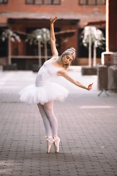 Beautiful young ballerina in tutu skirt dancing on city street — Stock Photo