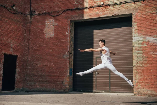 Joven bailarina de ballet bailando en salto en la calle de la ciudad - foto de stock