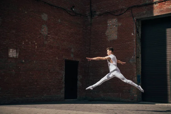 Молодая артистка балета в прыжке на городской улице — стоковое фото