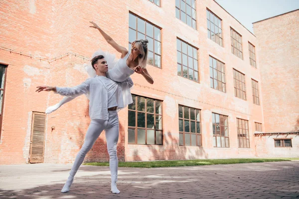 Молоді танцюристи балету в білому одязі танцюють на міській вулиці міста — стокове фото