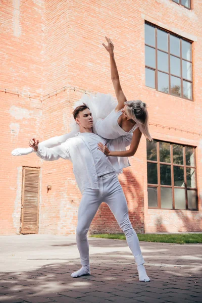 Молоді танцюристи балету в білому одязі танцюють на міській вулиці — стокове фото