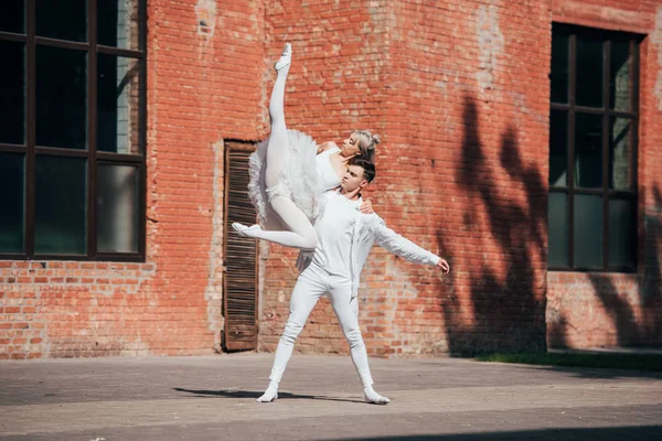 Pareja de jóvenes bailarines bailando en la calle de la ciudad - foto de stock