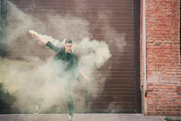 Beau danseur contemporain masculin en fumée jaune dans la rue urbaine — Photo de stock