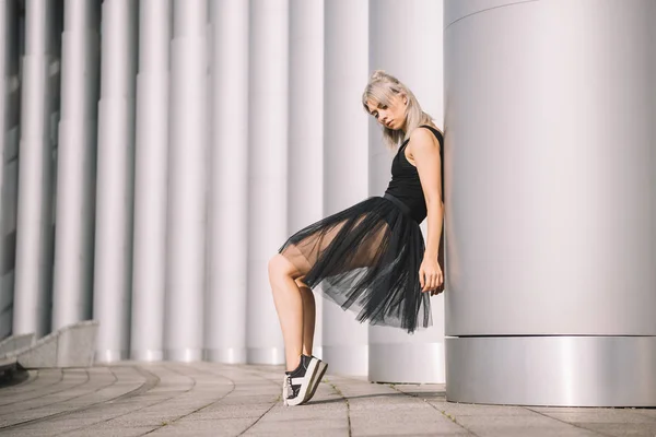 Vista laterale di bella giovane ballerina appoggiata alla colonna — Foto stock