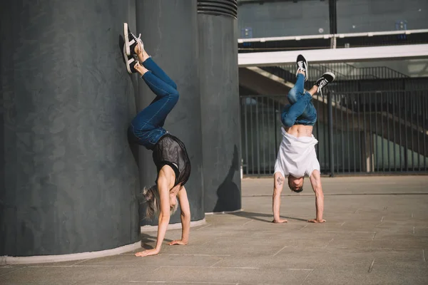 Joven pareja de bailarines realizando handstand en calle - foto de stock
