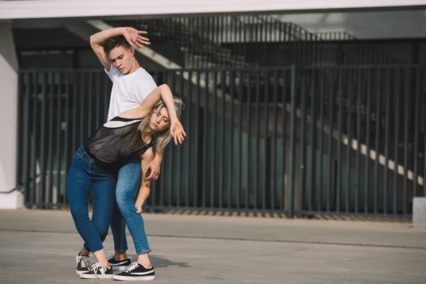 Joven pareja de bailarines practicando en la calle urbana de la ciudad - foto de stock