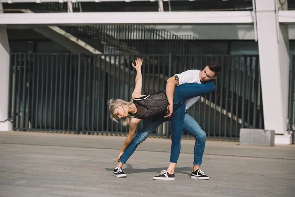 Young couple of contemporary dancers performing street dance in city — Stock Photo
