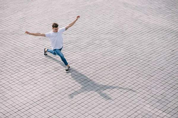 Blick aus der Vogelperspektive auf einen hübschen jungen Mann, der zeitgenössischen Tanz auf der Straße aufführt — Stockfoto
