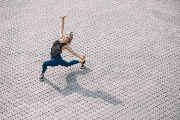 Vista de ángulo alto de hermosa chica realizando danza contemporánea en la calle - foto de stock