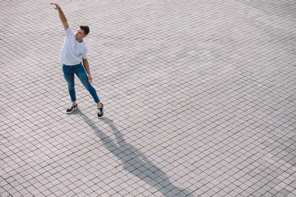 Blick aus der Vogelperspektive auf einen jungen Mann, der zeitgenössischen Tanz auf der Straße aufführt — Stockfoto