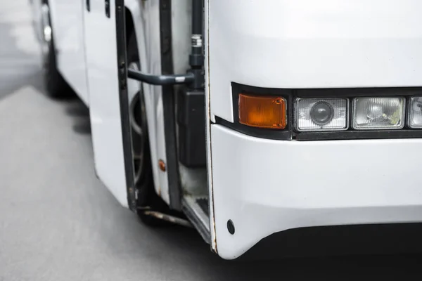 Close up view of white travel bus headlights at city street — Stock Photo