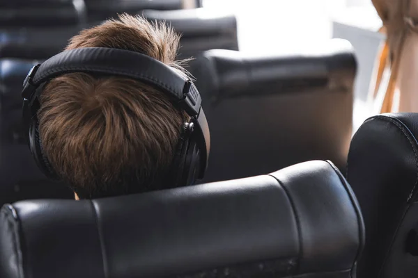 Vue arrière du touriste masculin dans les écouteurs écoutant de la musique pendant le voyage en bus — Photo de stock