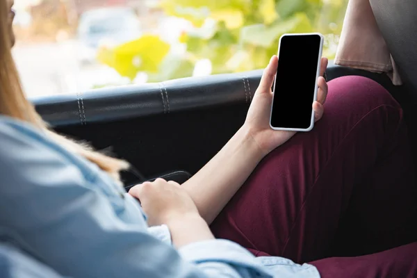 Imagen recortada de la mujer usando teléfono inteligente con pantalla en blanco durante el viaje en autobús - foto de stock