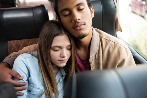 Vista de ángulo alto de pareja interracial durmiendo durante el viaje en autobús de viaje - foto de stock