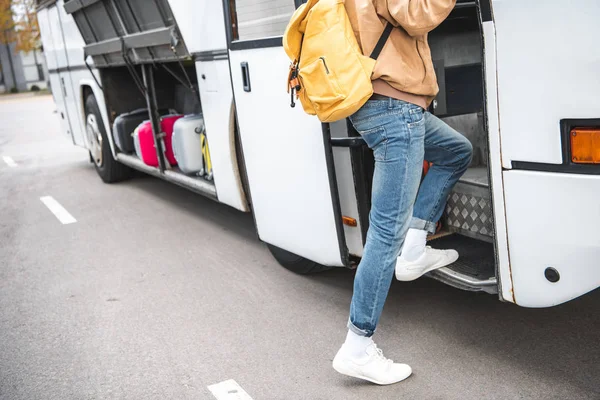 Abgeschnittenes Bild eines männlichen Touristen mit Rucksack, der an der Stadtstraße in einen Reisebus einsteigt — Stockfoto