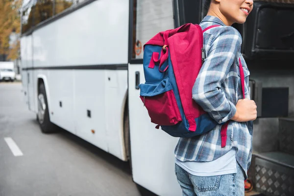 Partial view of female tourist with backpack walking into travel bus at urban srtreet — Stock Photo