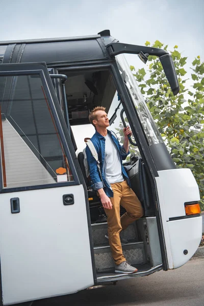 Bellissimo viaggiatore maschio con zaino a piedi fuori dal bus di viaggio in strada — Foto stock