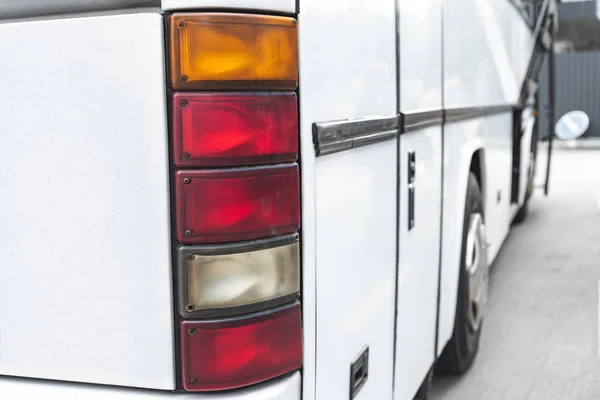 Selective focus of white travel bus headlights at urban street — Stock Photo