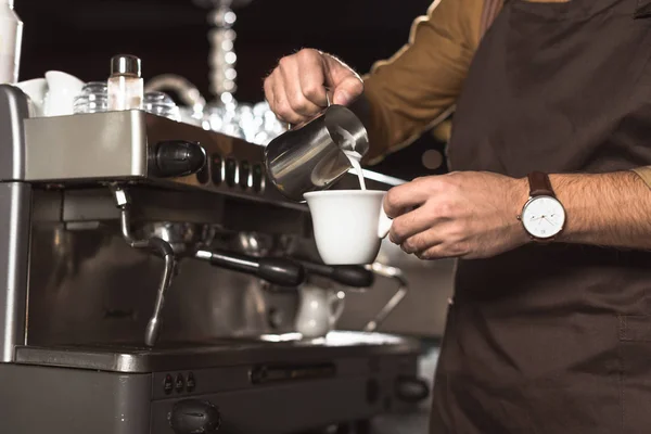 Plan recadré de barista verser du lait dans le café tout en le préparant dans le café — Photo de stock
