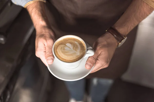 Tiro cortado de barista segurando xícara de cappuccino feito fresco — Fotografia de Stock