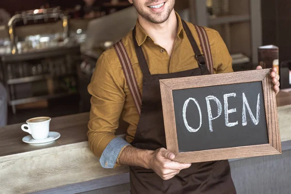 Plan recadré de jeune garçon heureux tenant tableau noir avec inscription ouverte dans le café — Photo de stock