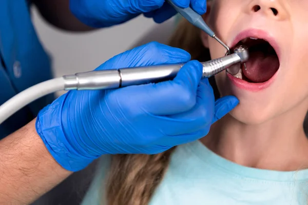 Dentista com peça dentária dentes de perfuração de criança — Fotografia de Stock