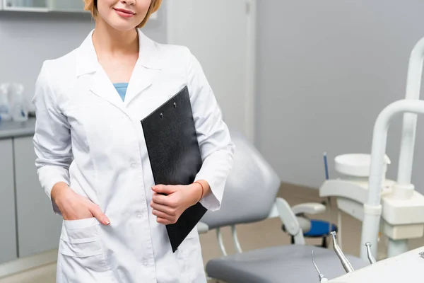 Обрізаний знімок молодого стоматолога з буфером, що стоїть в офісі — стокове фото