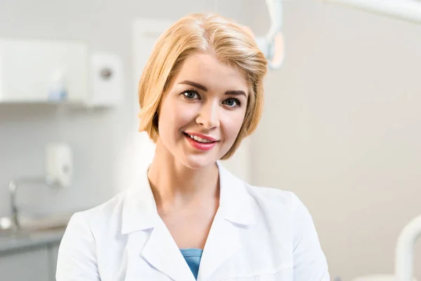 Close-up portrait of beautiful young dentist looking at camera in office — Stock Photo