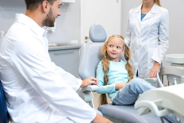 Young male and female dentists working with little child — Stock Photo