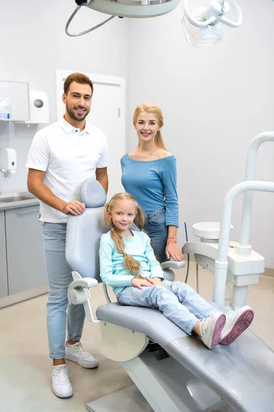 Красива молода сім'я дивиться на камеру в стоматологічному кабінеті — стокове фото