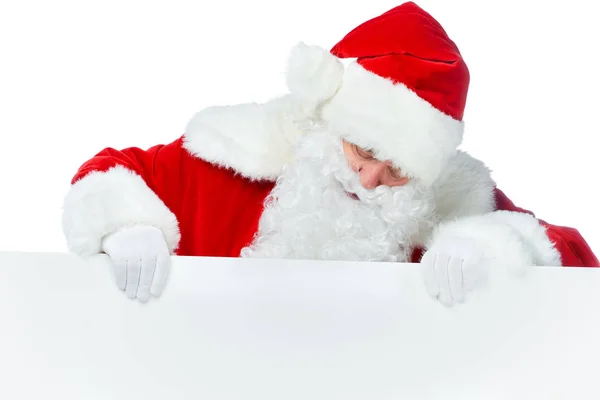 Bearded santa claus looking at empty board isolated on white — Stock Photo
