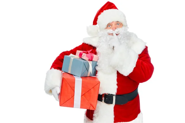 Weihnachtsmann mit Weihnachtsgeschenken zeigt Schweigesymbol isoliert auf weiß — Stockfoto