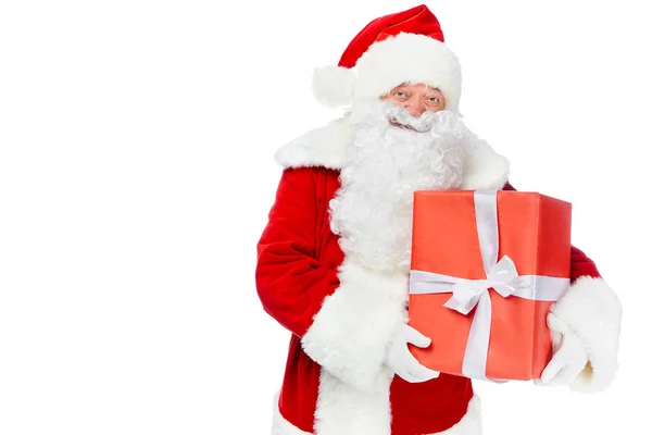 Happy santa claus holding red christmas gift isolated on white — Stock Photo