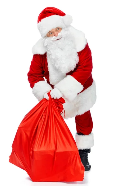 Santa claus holding red christmas bag isolated on white — Stock Photo