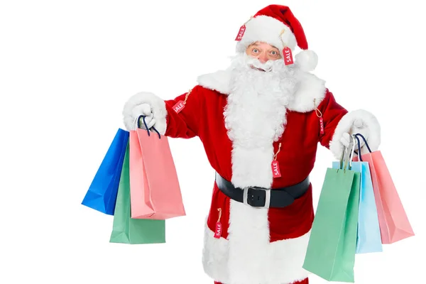 Barbudo santa claus en traje rojo con etiquetas de venta sosteniendo bolsas aisladas en blanco - foto de stock